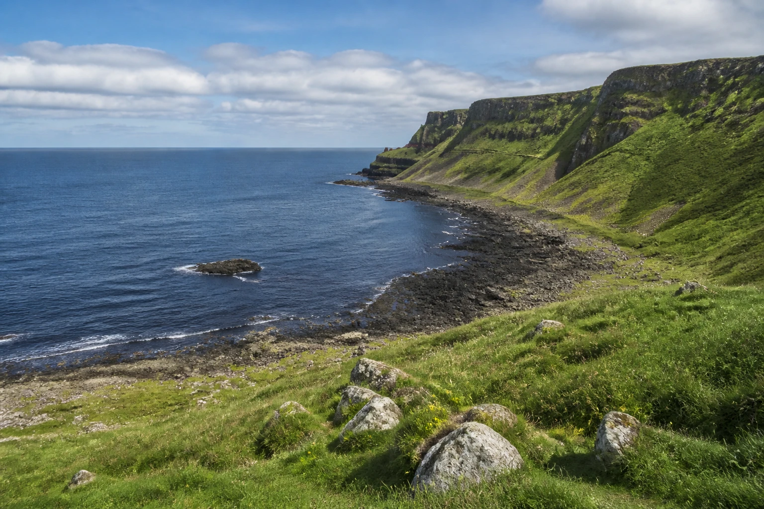 Representative coastal destination view: Antrim Coast and Giant's Causeway, United Kingdom; coastline and regional vegetation, not an exact landmark photograph.