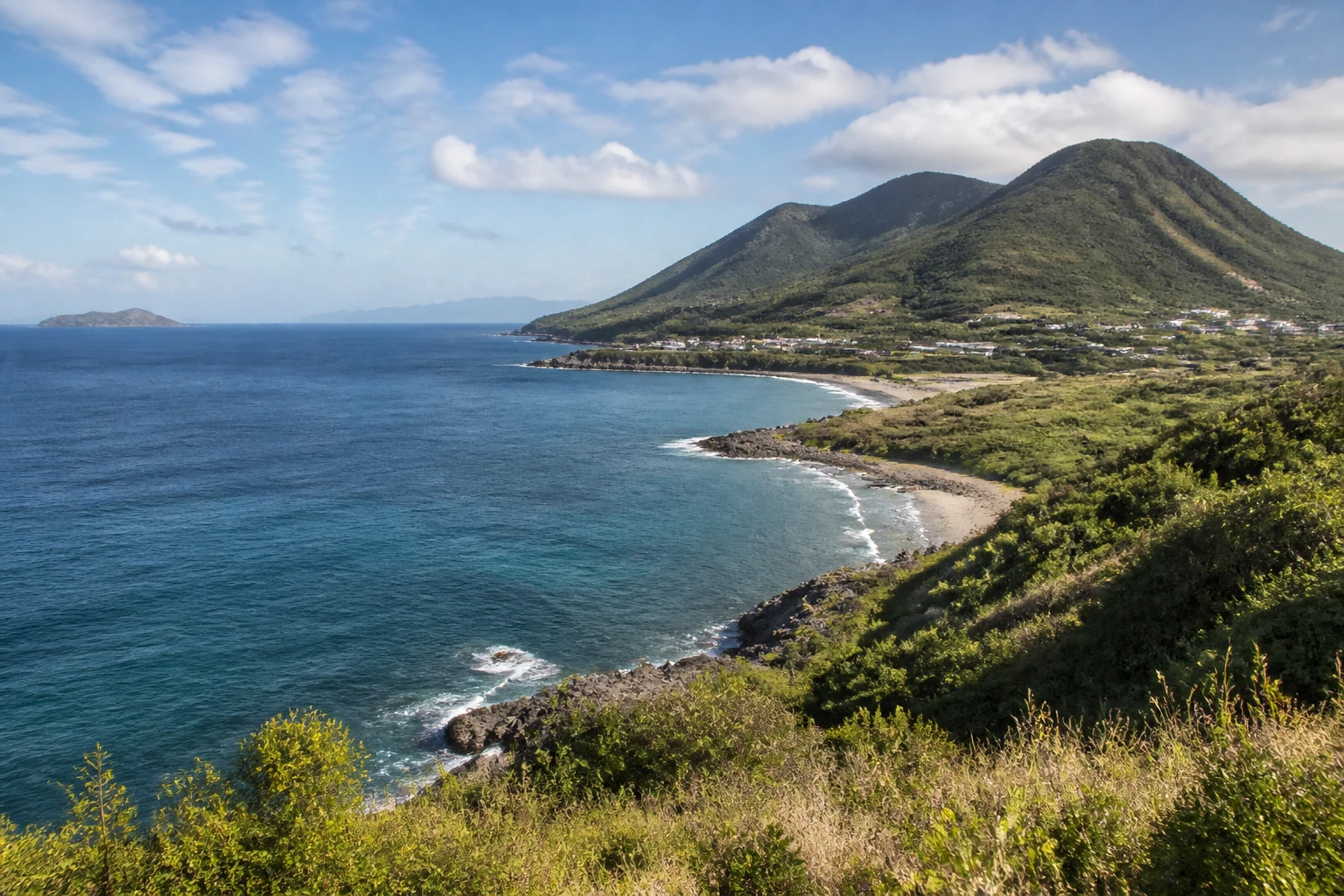 Representative island destination view of Nevis, with coastline, shoreline geology, regional vegetation, and natural light; not an exact landmark photograph.
