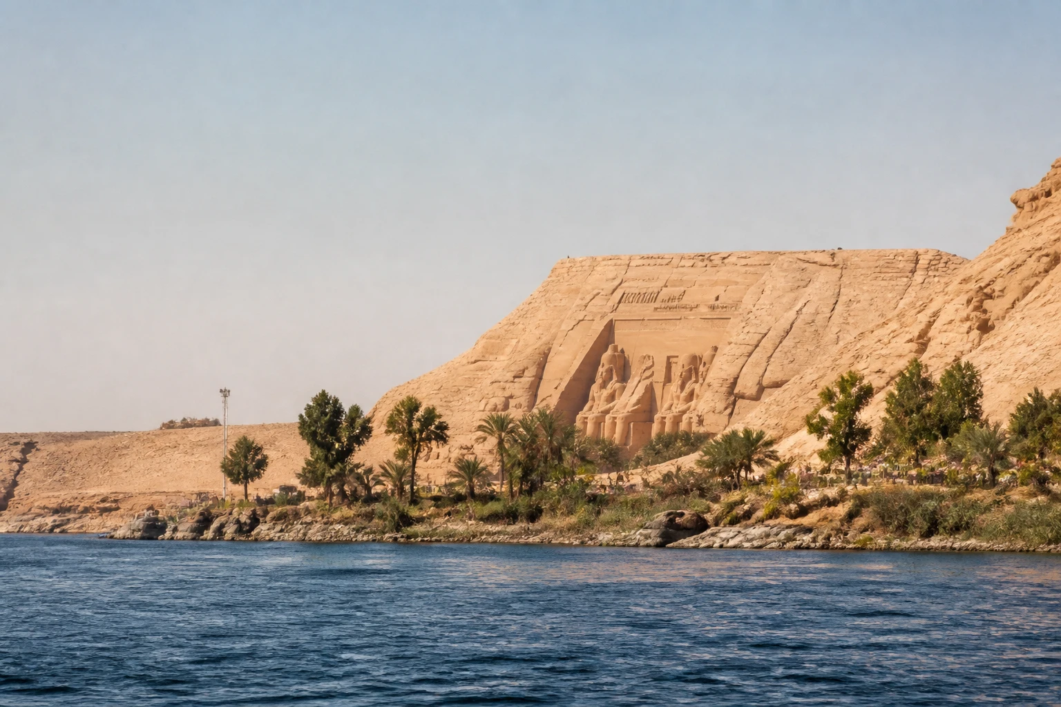 Representative river destination view: Abu Simbel, Egypt; inland water, regional terrain, and vegetation, not an exact landmark photograph.