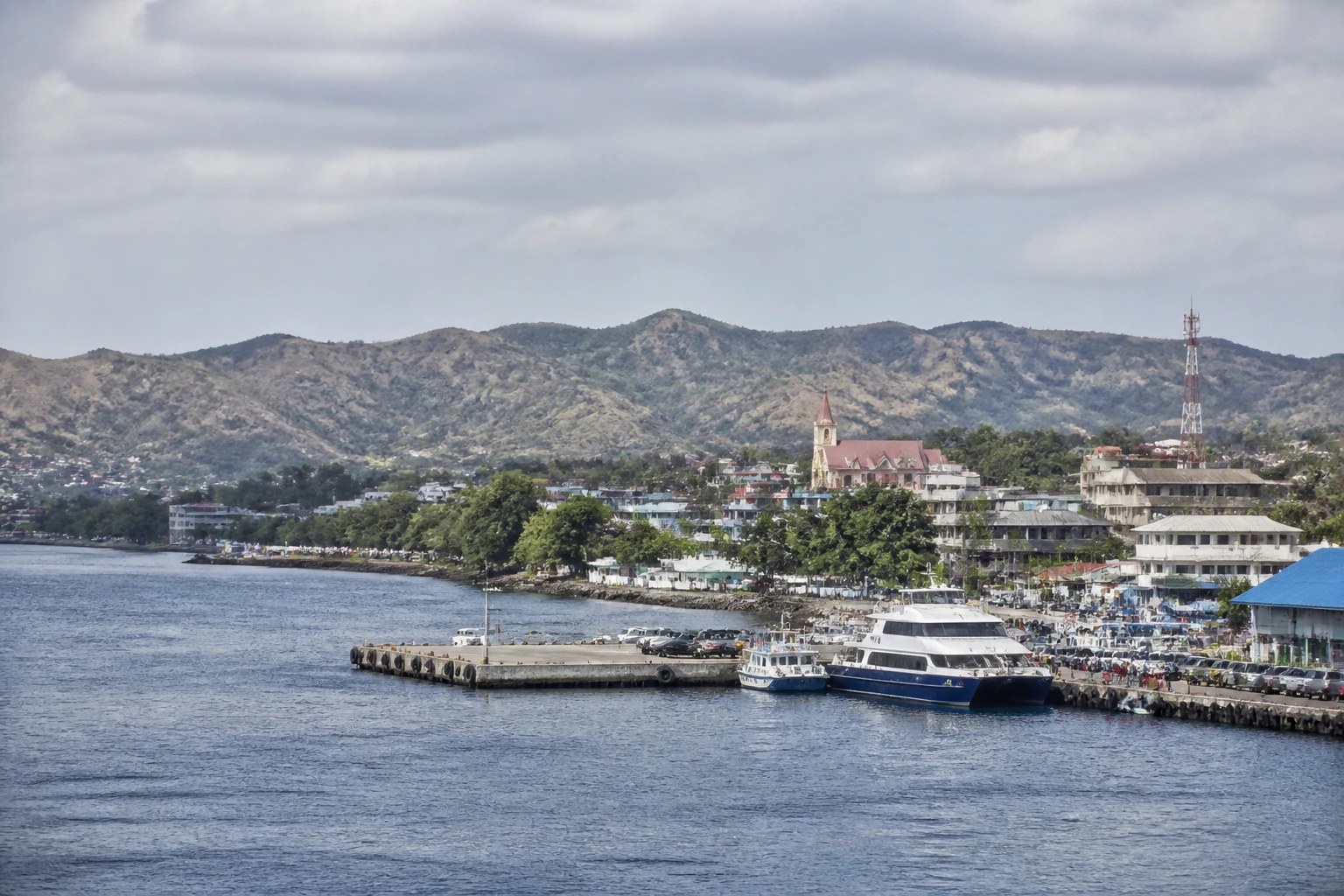 Representative cruise port destination view: Kupang, Indonesia; passenger waterfront and harbor water, not an exact landmark photograph.