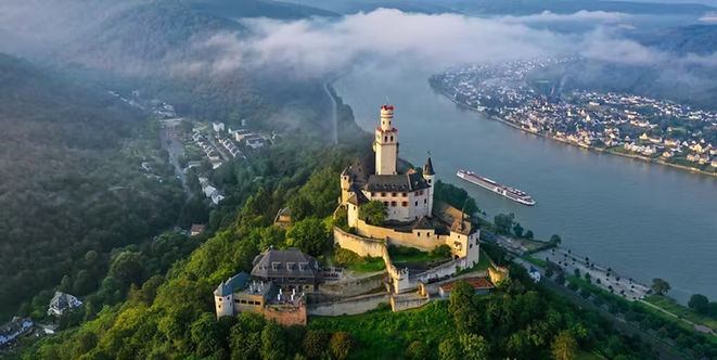 Marksburg Castle perched above the Rhine River and wooded hills near Braubach, Germany.