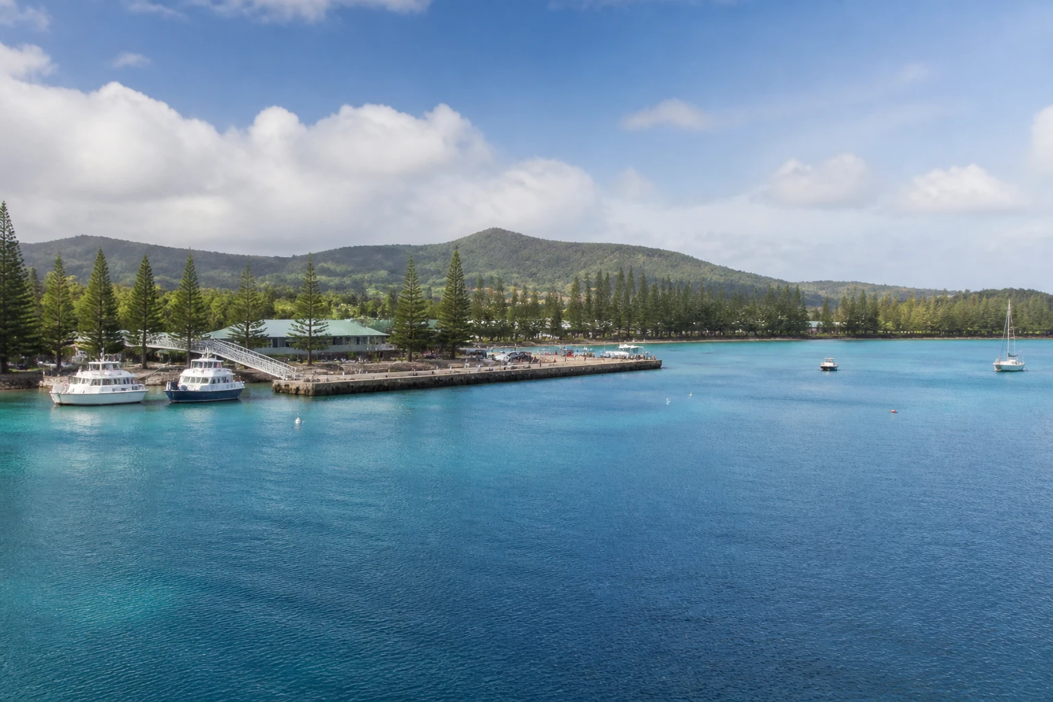 Representative cruise port destination view: Ile des Pins, New Caledonia; passenger waterfront and harbor water, not an exact landmark photograph.