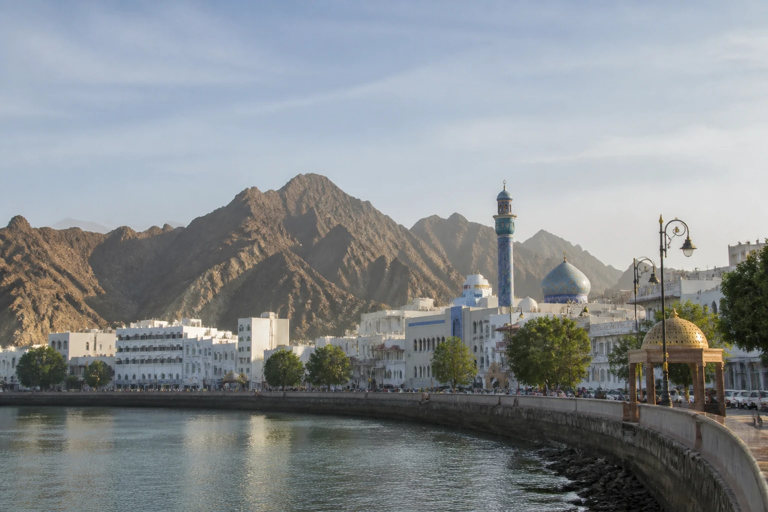 Representative city destination view: Muscat, Oman; passenger waterfront and harbor water, not an exact landmark photograph.