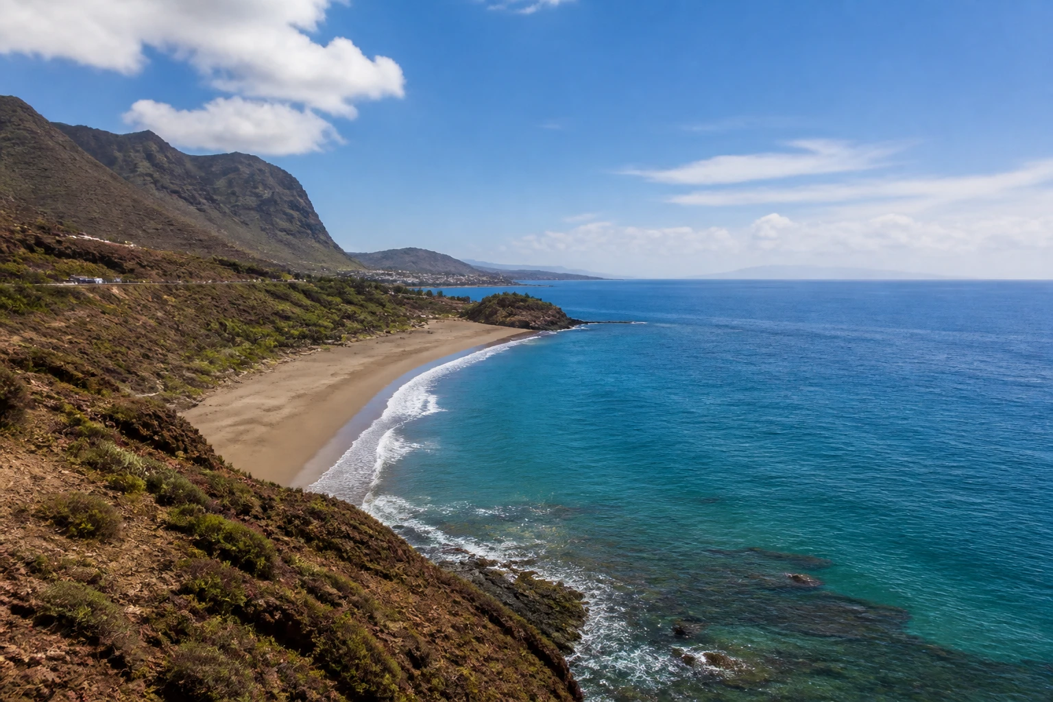 Representative island destination view: Tenerife, Spain; coastline and regional vegetation, not an exact landmark photograph.