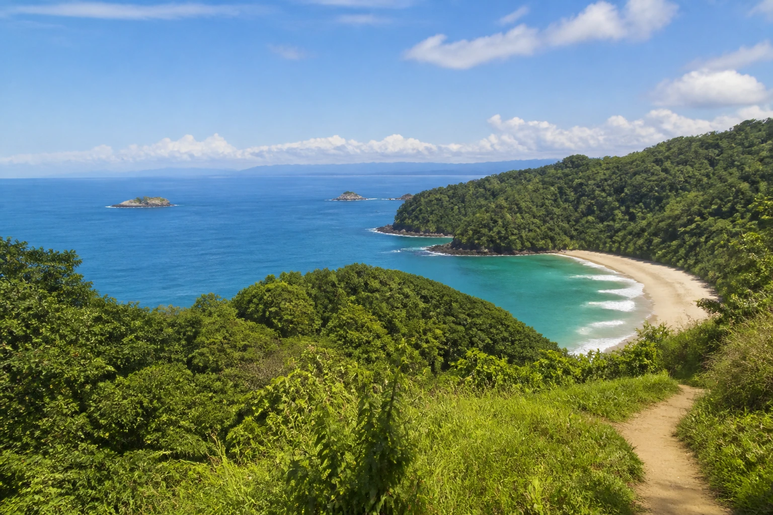 Representative national park destination view: Manuel Antonio, Costa Rica; protected terrain and native vegetation, not an exact landmark photograph.