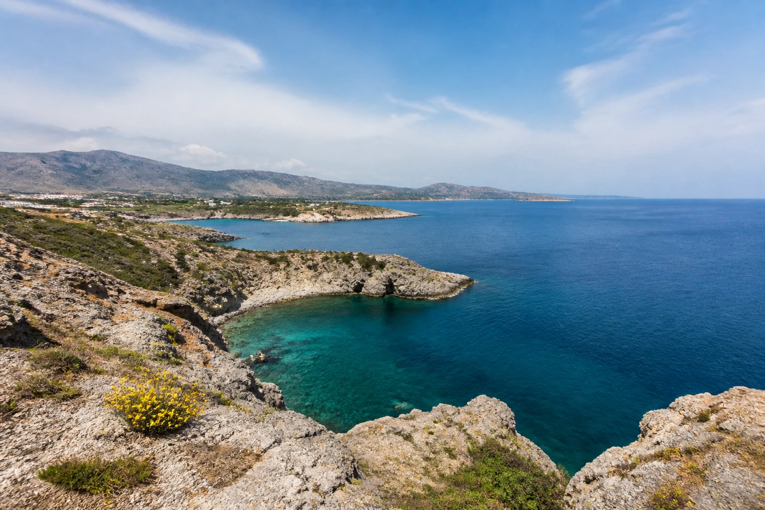 Representative island destination view: Rhodes, Greece; coastline and regional vegetation, not an exact landmark photograph.