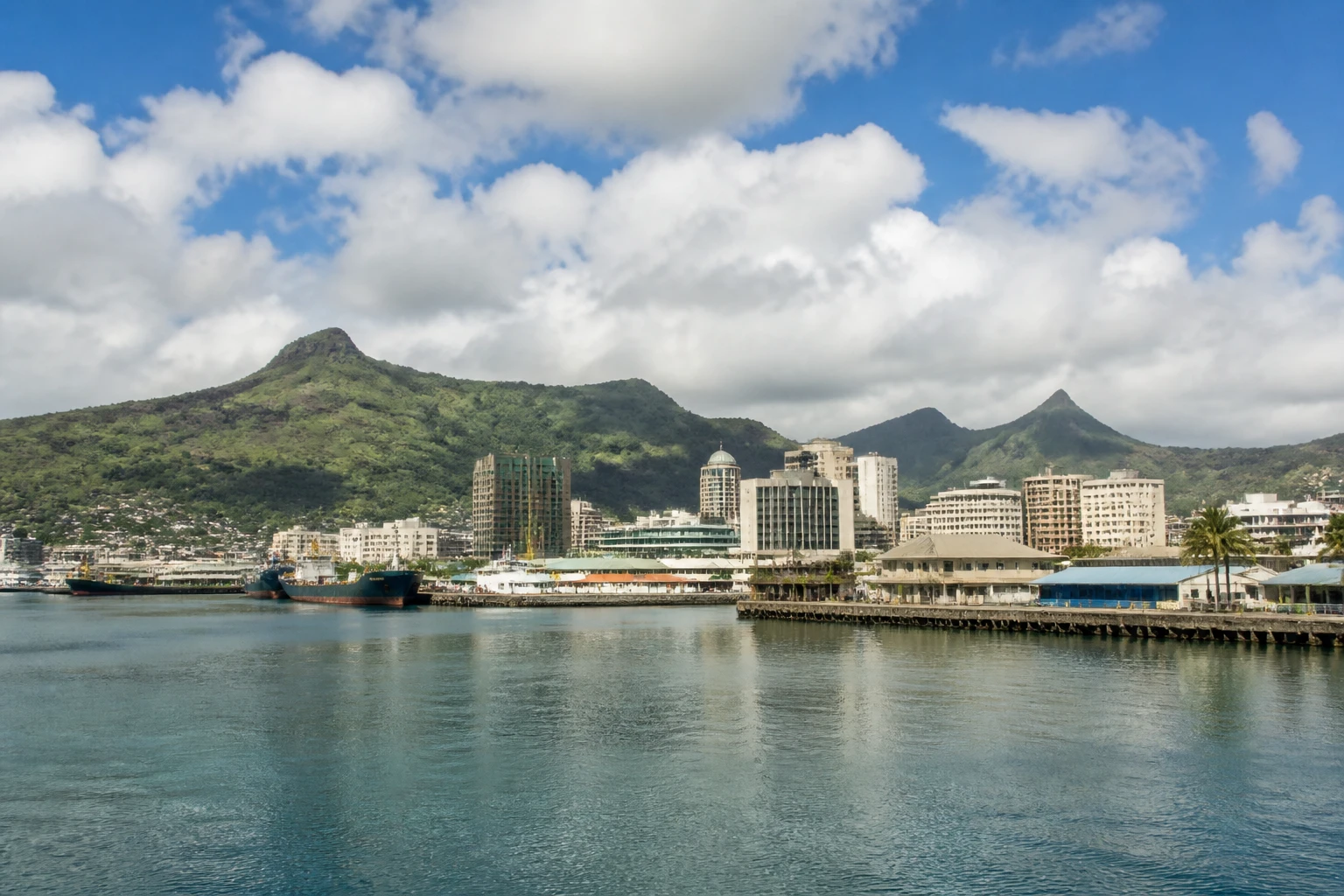 Representative cruise port destination view: Port Louis, Mauritius; passenger waterfront and harbor water, not an exact landmark photograph.