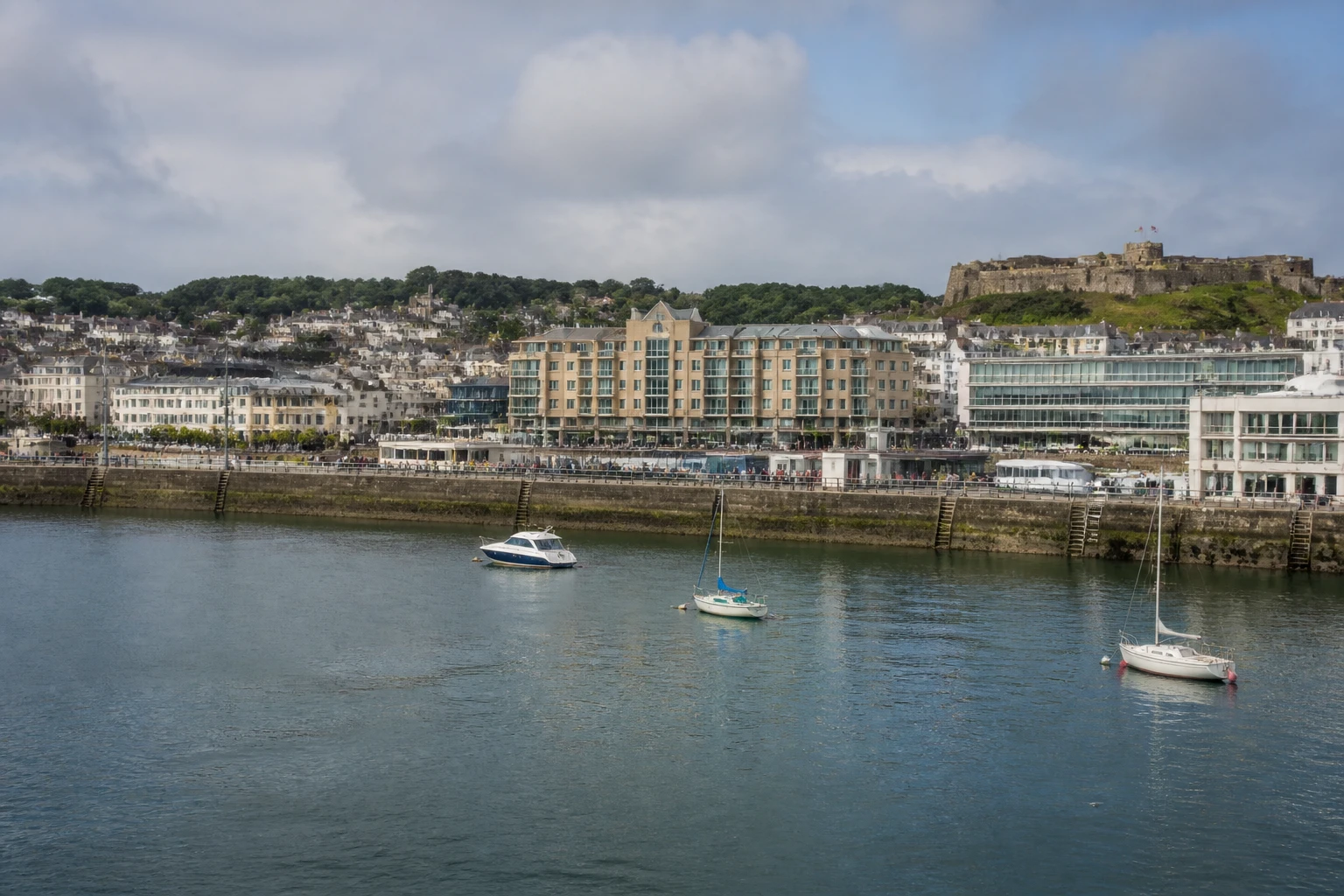 Representative cruise port destination view: St. Helier, Channel Islands; passenger waterfront and harbor water, not an exact landmark photograph.