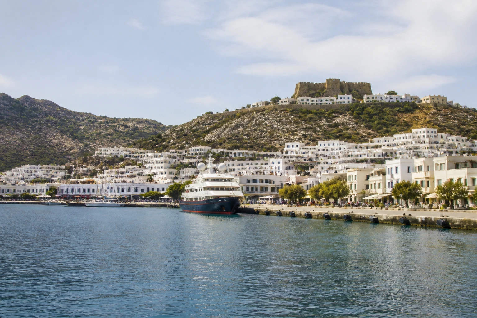 Representative cruise port destination view: Patmos, Greece; passenger waterfront and harbor water, not an exact landmark photograph.