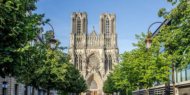 The twin Gothic towers and ornate façade of Notre-Dame Cathedral in Reims, France.