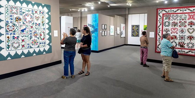 Visitors viewing large colorful quilts displayed inside the National Quilt Museum in Paducah, Kentucky.