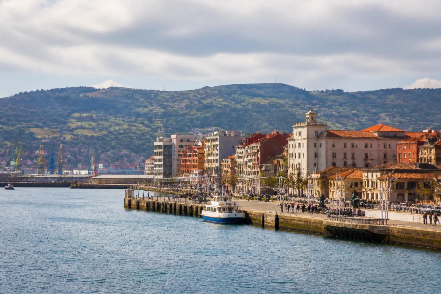 Representative cruise port destination view: Gijon, Spain; passenger waterfront and harbor water, not an exact landmark photograph.