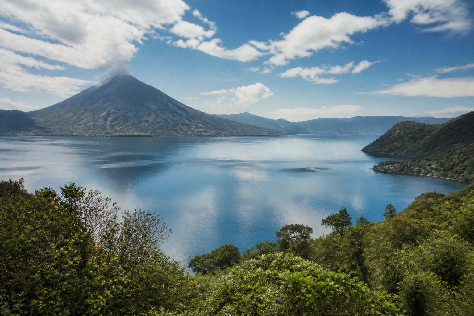 Representative lake destination view: Lake Atitlan, Guatemala; inland water, regional terrain, and vegetation, not an exact landmark photograph.
