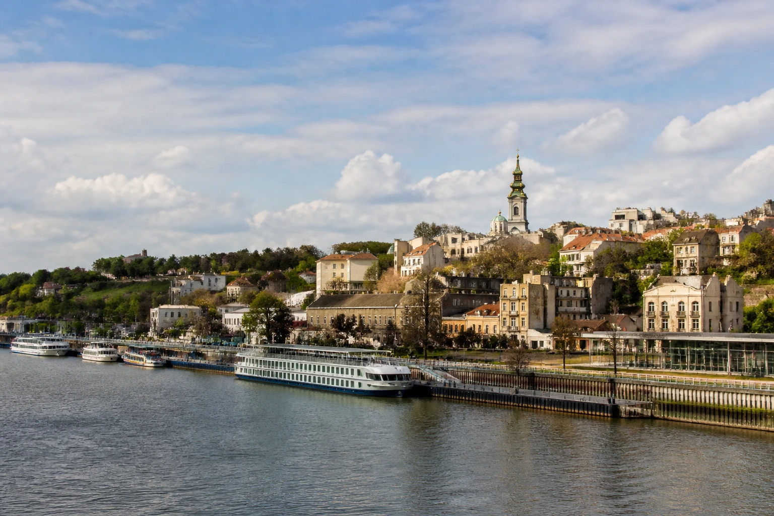 Representative river destination view: Belgrade, Serbia; inland water, regional terrain, and vegetation, not an exact landmark photograph.