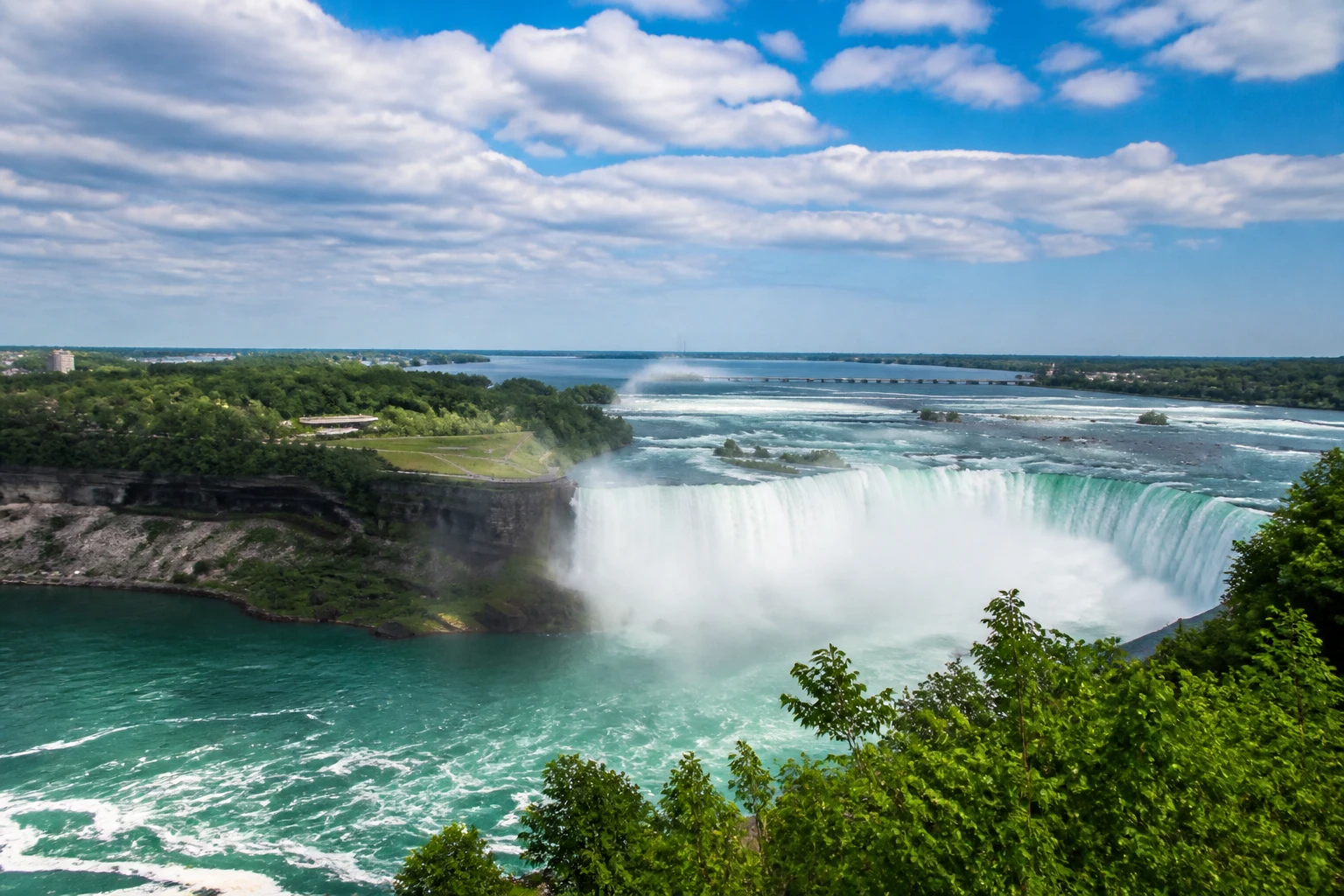 Representative nature destination view: Niagara Falls, Canada / United States; inland water, regional terrain, and vegetation, not an exact landmark photograph.
