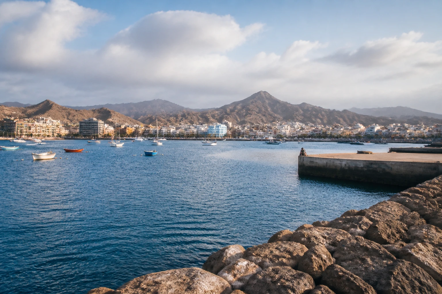 Representative cruise port destination view: Mindelo, Cape Verde; passenger waterfront and harbor water, not an exact landmark photograph.