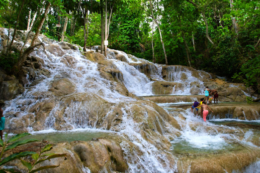 Tropical waterfalls and visitors climbing Dunn’s River Falls near Ocho Rios, Jamaica