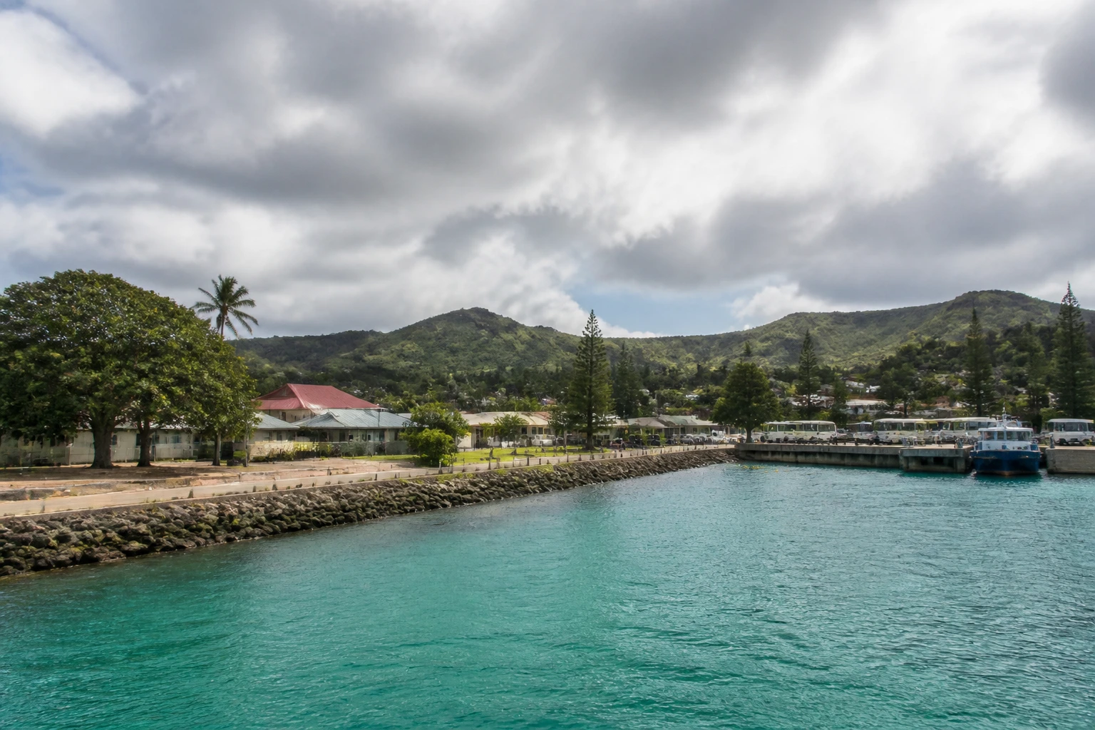 Representative cruise port destination view: Lifou, New Caledonia; passenger waterfront and harbor water, not an exact landmark photograph.