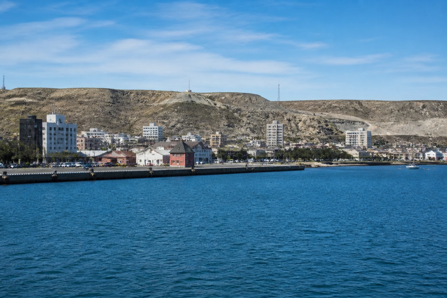 Representative cruise port destination view: Puerto Madryn, Argentina; passenger waterfront and harbor water, not an exact landmark photograph.