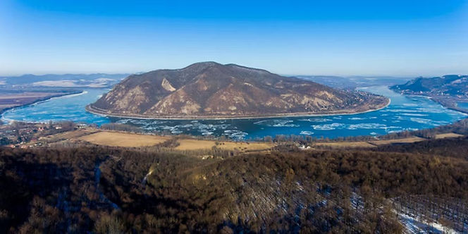 River scenery, wooded shorelines and reflective water along Scenic Sailing Danube Bend.