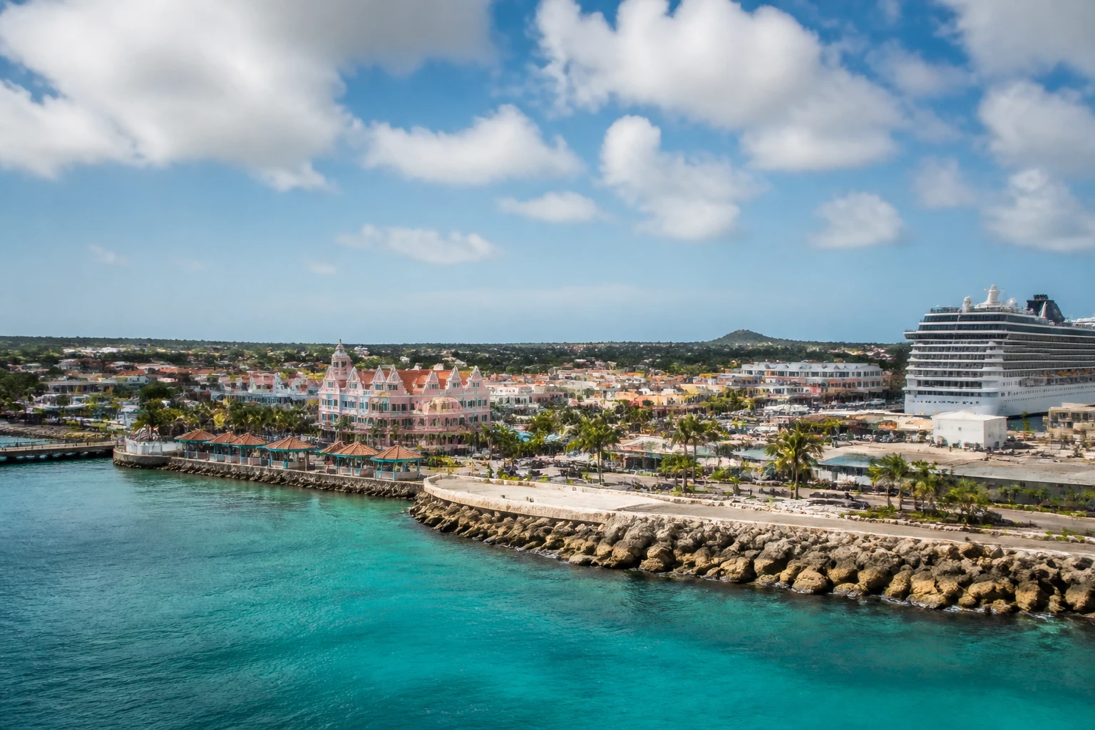 Representative cruise port destination view: Oranjestad, Aruba; passenger waterfront and harbor water, not an exact landmark photograph.