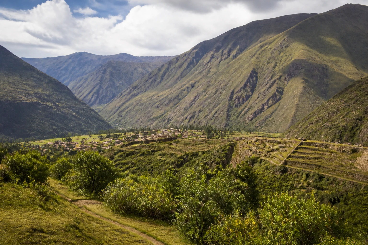 Representative mountain destination view: Sacred Valley, Peru; mountain or canyon terrain and regional vegetation, not an exact landmark photograph.