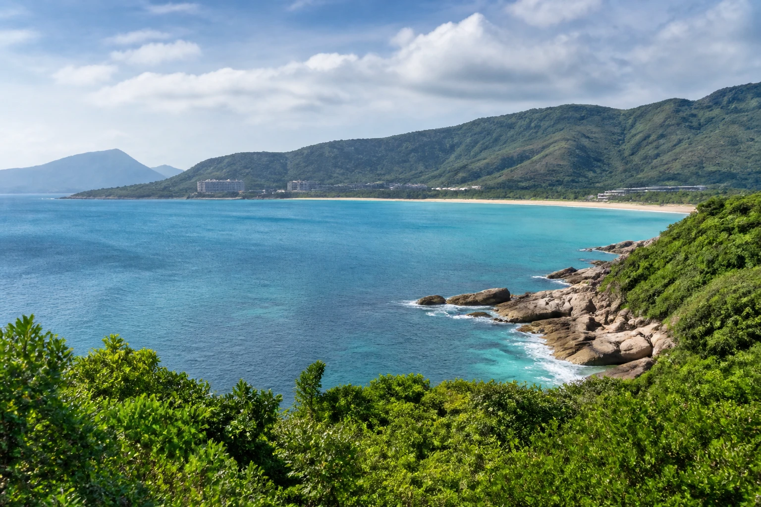 Representative island destination view: Hainan and Sanya, China; coastline and regional vegetation, not an exact landmark photograph.