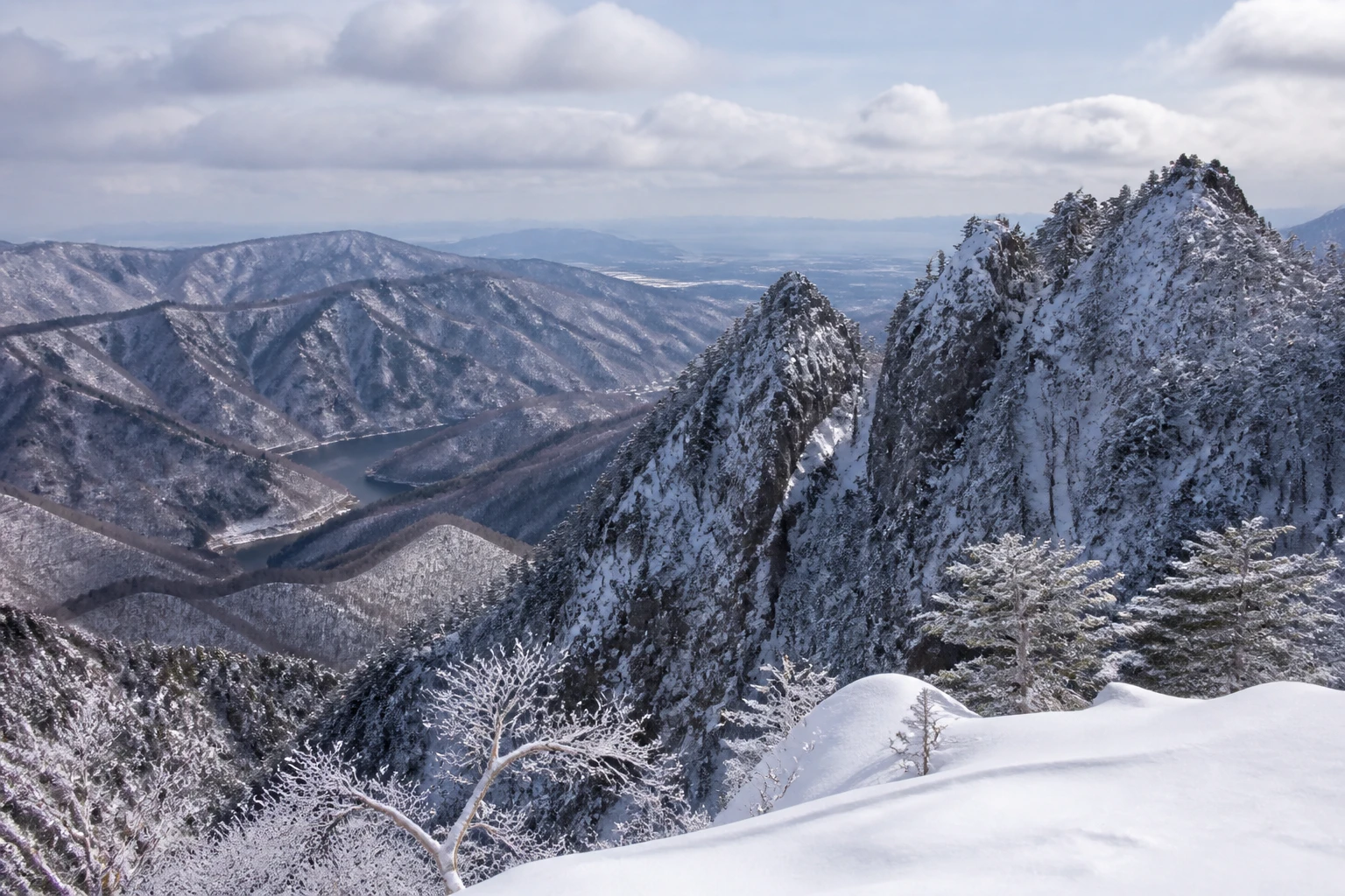 Representative island destination view: Hokkaido and Sapporo, Japan; mountain or canyon terrain and regional vegetation, not an exact landmark photograph.