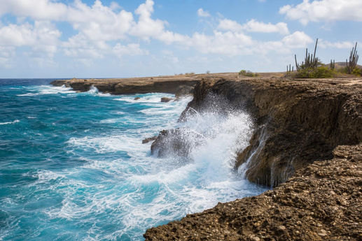 Ocean waves crashing against Curaçao's rugged limestone north coast