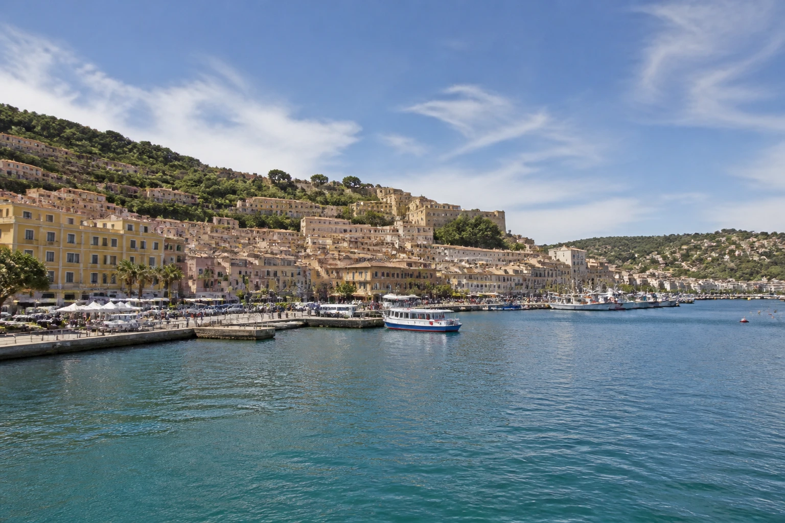 Representative cruise port destination view: Porto Santo Stefano, Italy; passenger waterfront and harbor water, not an exact landmark photograph.