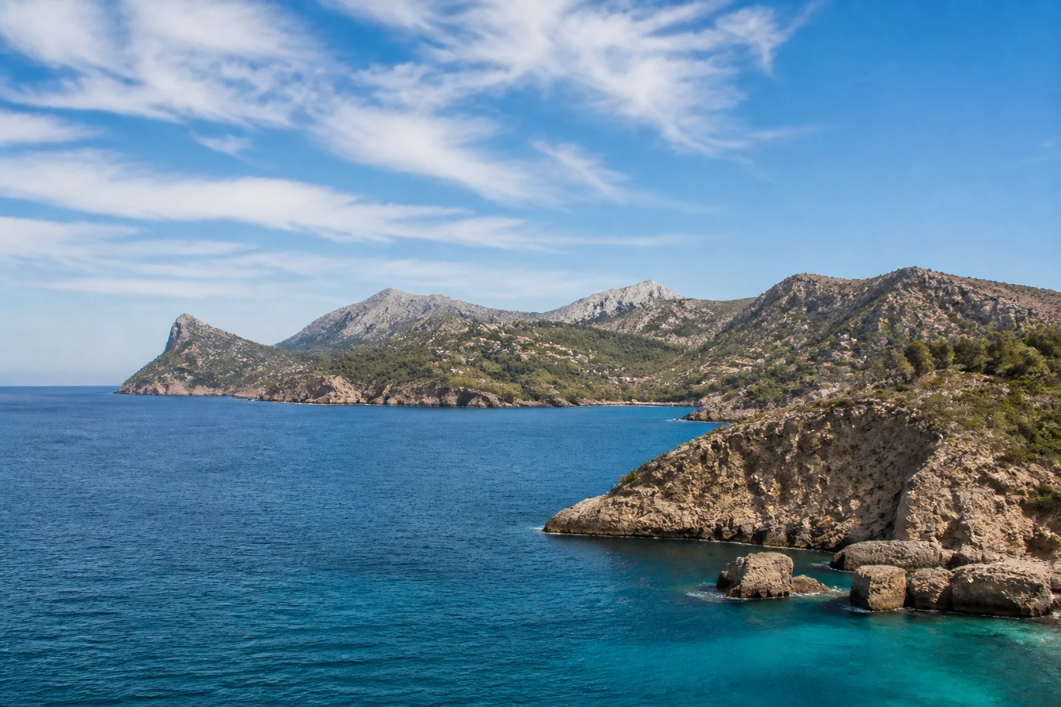Representative island destination view: Mallorca, Spain; coastline and regional vegetation, not an exact landmark photograph.