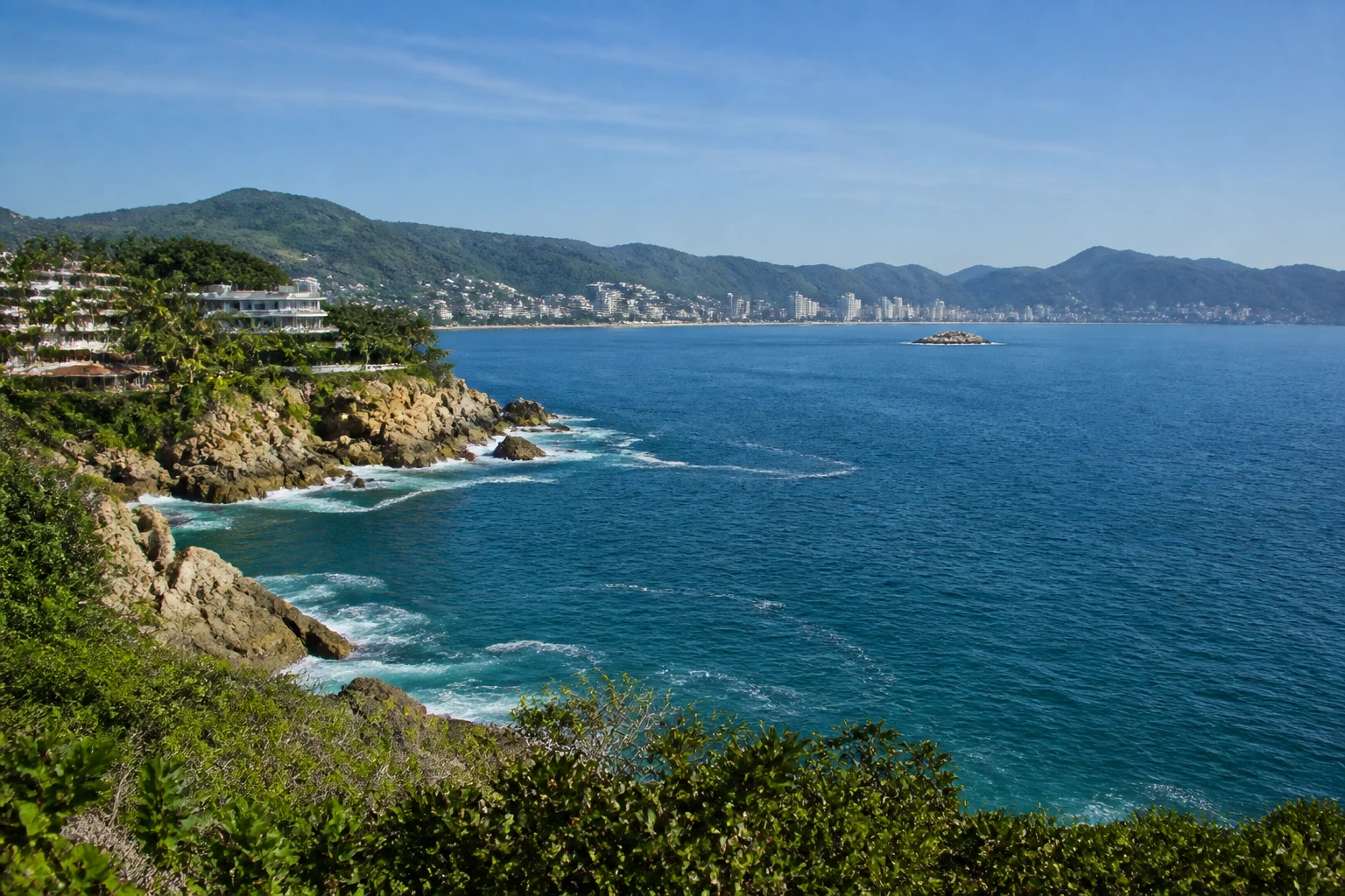 Representative coastal destination view: Acapulco, Mexico; coastline and regional vegetation, not an exact landmark photograph.