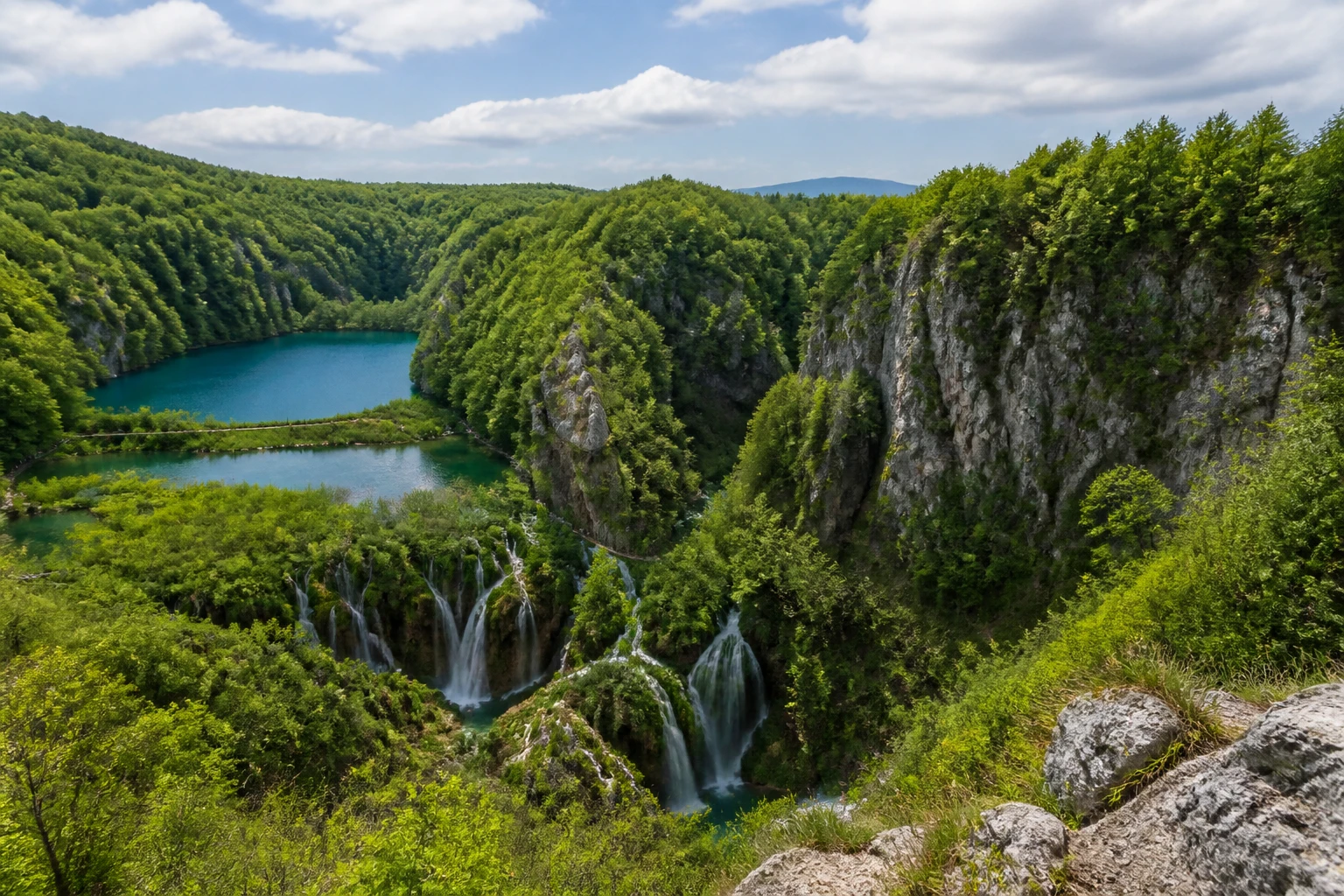 Representative national park destination view: Plitvice Lakes National Park, Croatia; protected terrain and native vegetation, not an exact landmark photograph.
