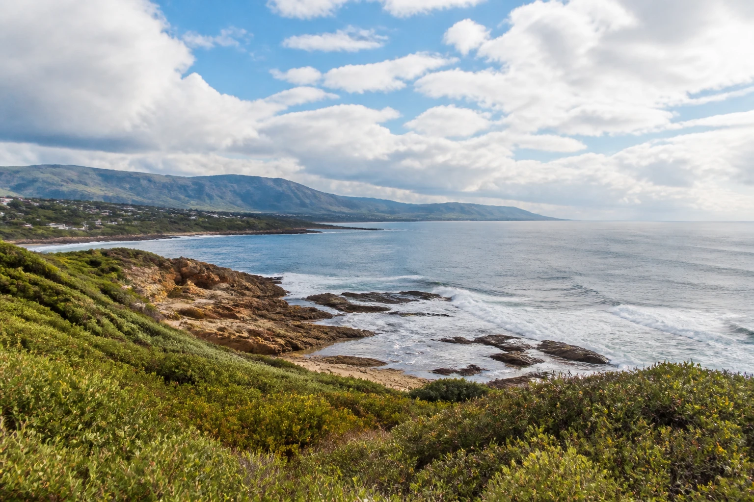 Representative coastal destination view: Garden Route, South Africa; coastline and regional vegetation, not an exact landmark photograph.