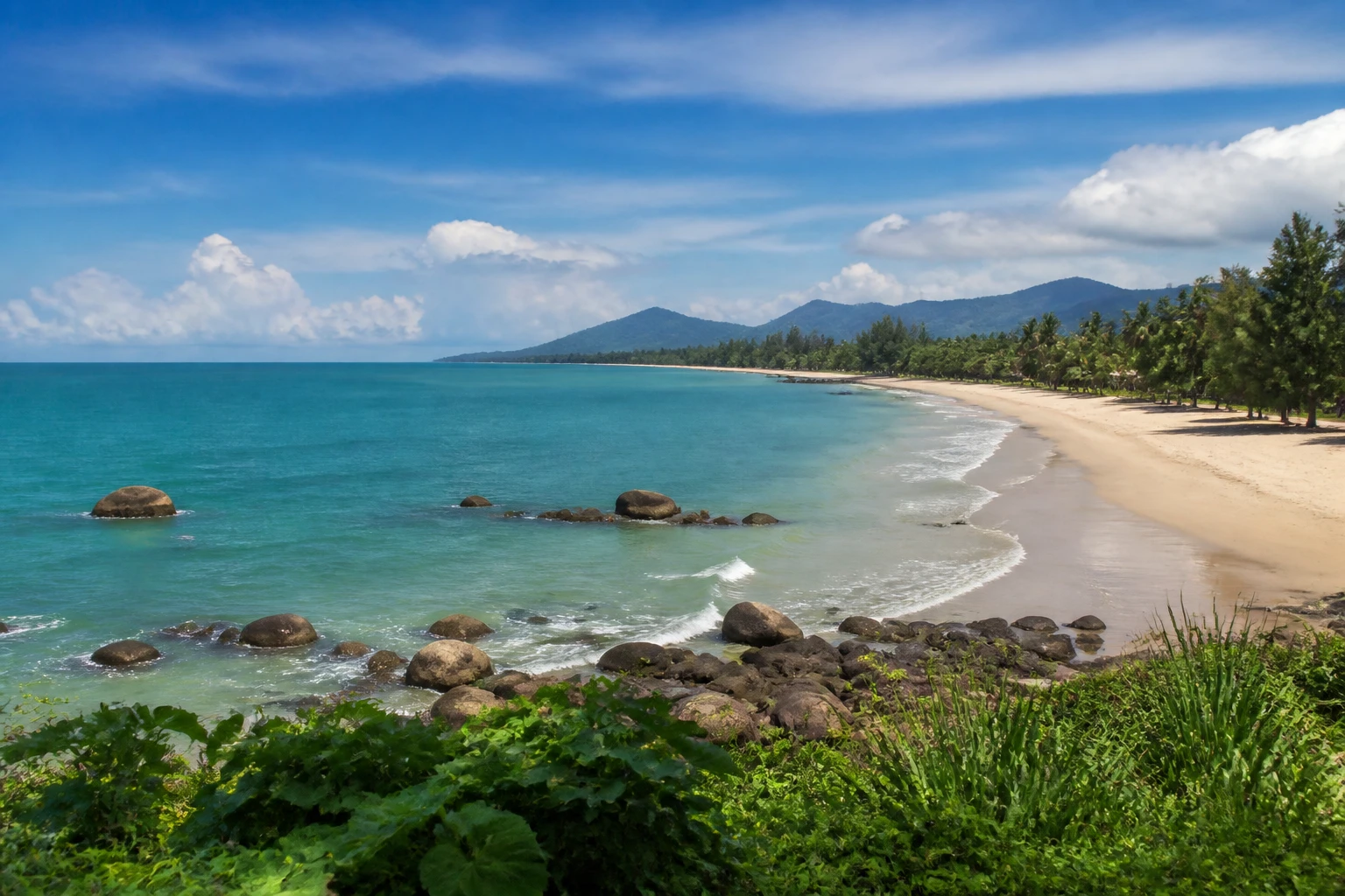 Representative coastal destination view: Khao Lak, Thailand; coastline and regional vegetation, not an exact landmark photograph.