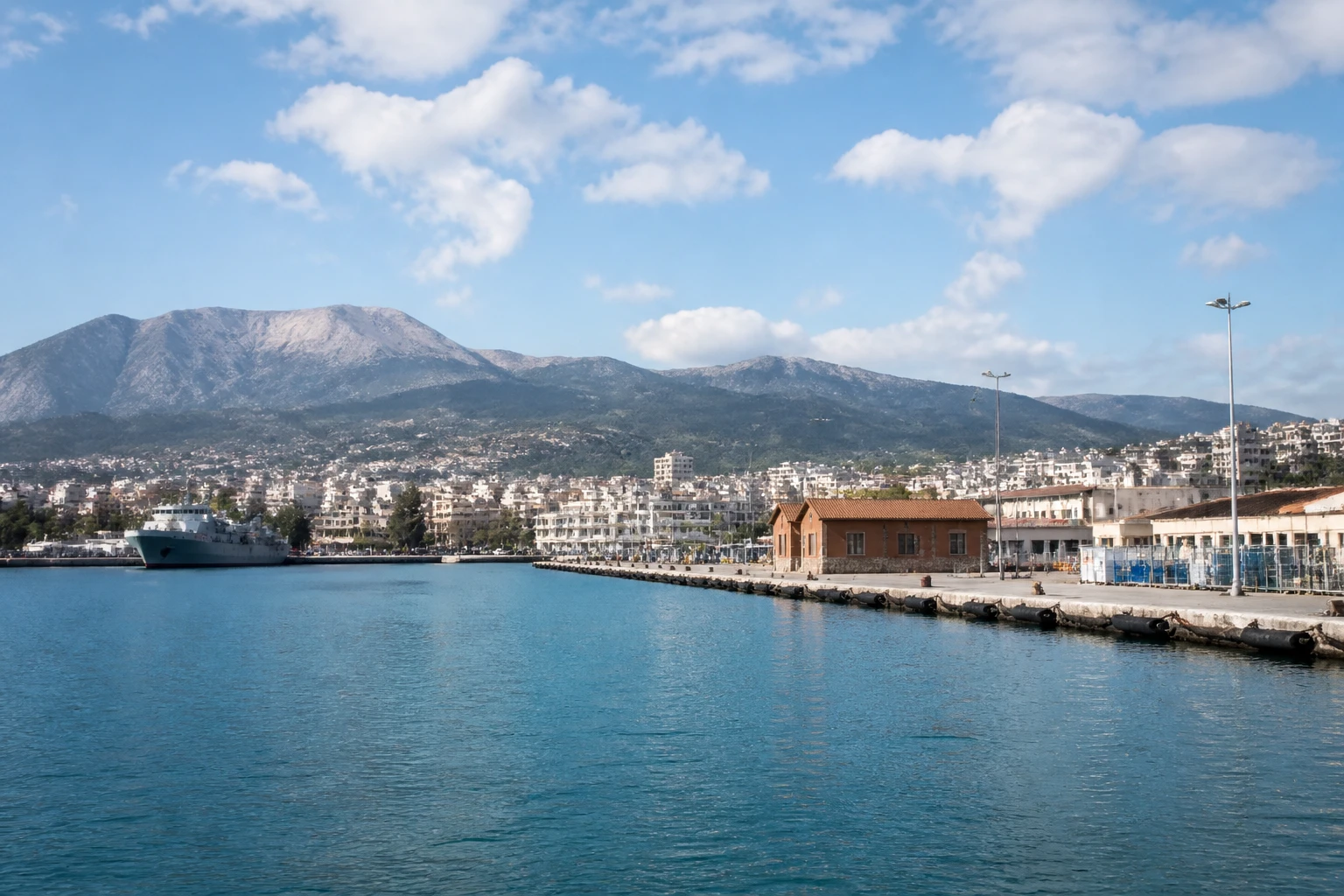 Representative cruise port destination view: Souda Bay, Greece; passenger waterfront and harbor water, not an exact landmark photograph.