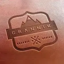 Logotipo Grannik Graphic Design, montañas y elementos. Termograbado con fondo bronce.
