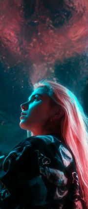 Joven rubia mira hacia arriba dentro de una visión futurista azul y roja.