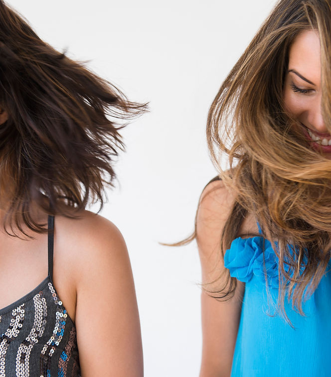 Two women swinging their hair