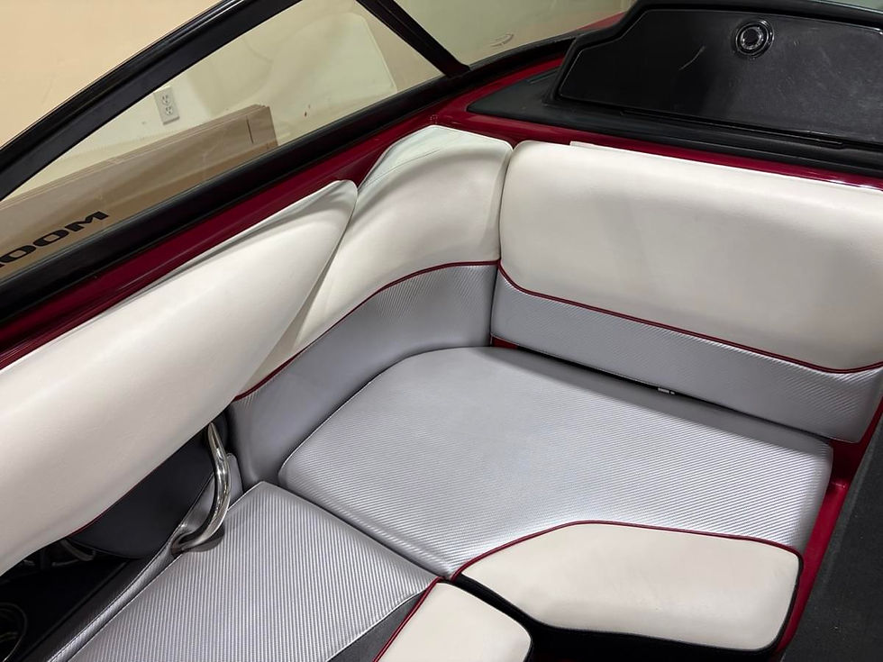 White and gray boat interior seats with red trim, reflecting modern design. Background includes a window and a glimpse of a wooden panel.