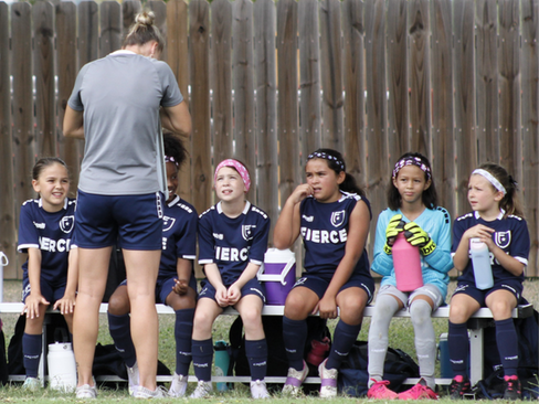 FIERCE Academy Director Rachelle D'Amico coaching Academy players at halftime