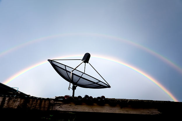 satellite-dish-on-the-roof-against-rainbow-sky-2023-11-27-05-08-29-utc.jpg