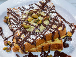 Delicious french toast with chocolate drizzle, pistachios and powdered sugar.