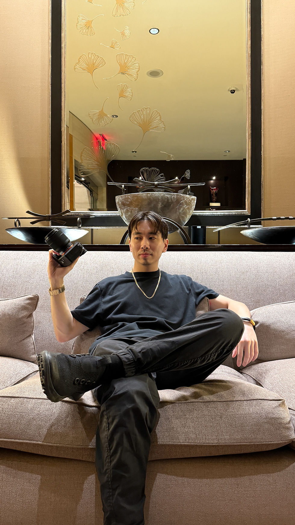 Vincent, professional dating app photographer and founder of Based Dating, sitting confidently with his camera in a luxury setting before an exclusive client photoshoot