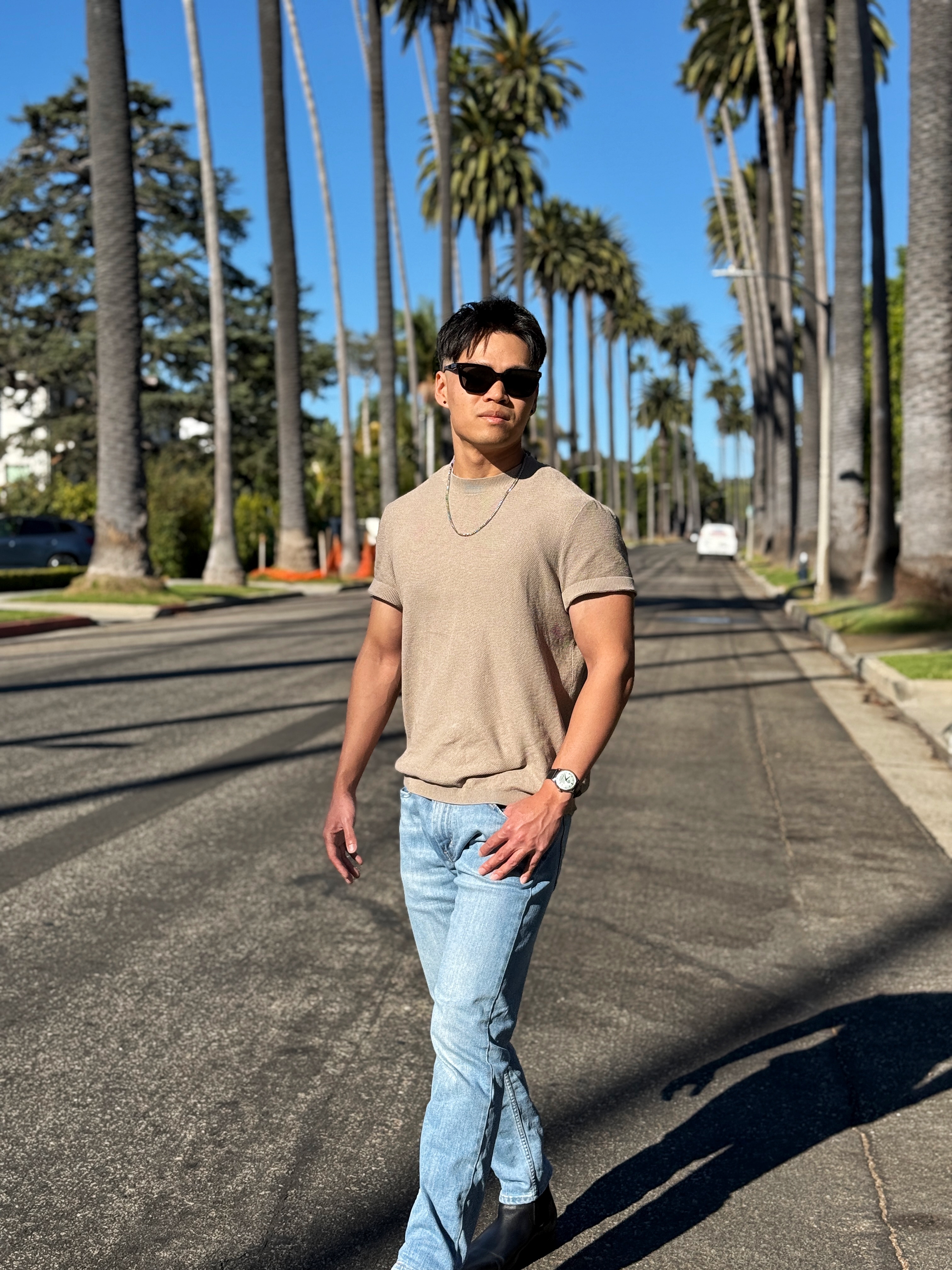 Professional dating app photo of a male client taken on a palm-lined street in Los Angeles