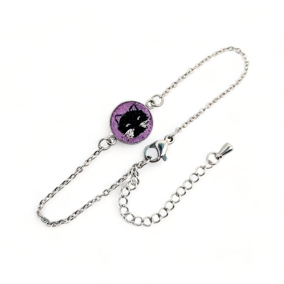 Photo du bracelet chat noir, avec le portait d'un chat en broderie sur un fond violet