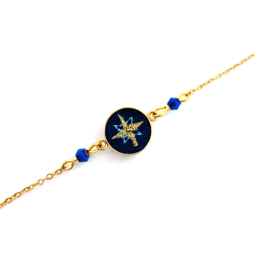 Miniature : Photo du bracelet étoile en broderie au fil d'or avec sa chaîne sur fond bleu nuit avec ses perles en cristal