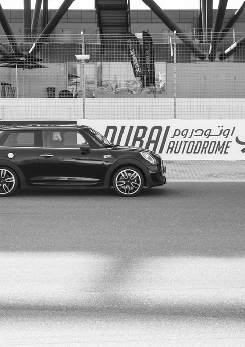 Blue and green Mini Coopers racing on a track, photographed for motorsport event photography in Dubai