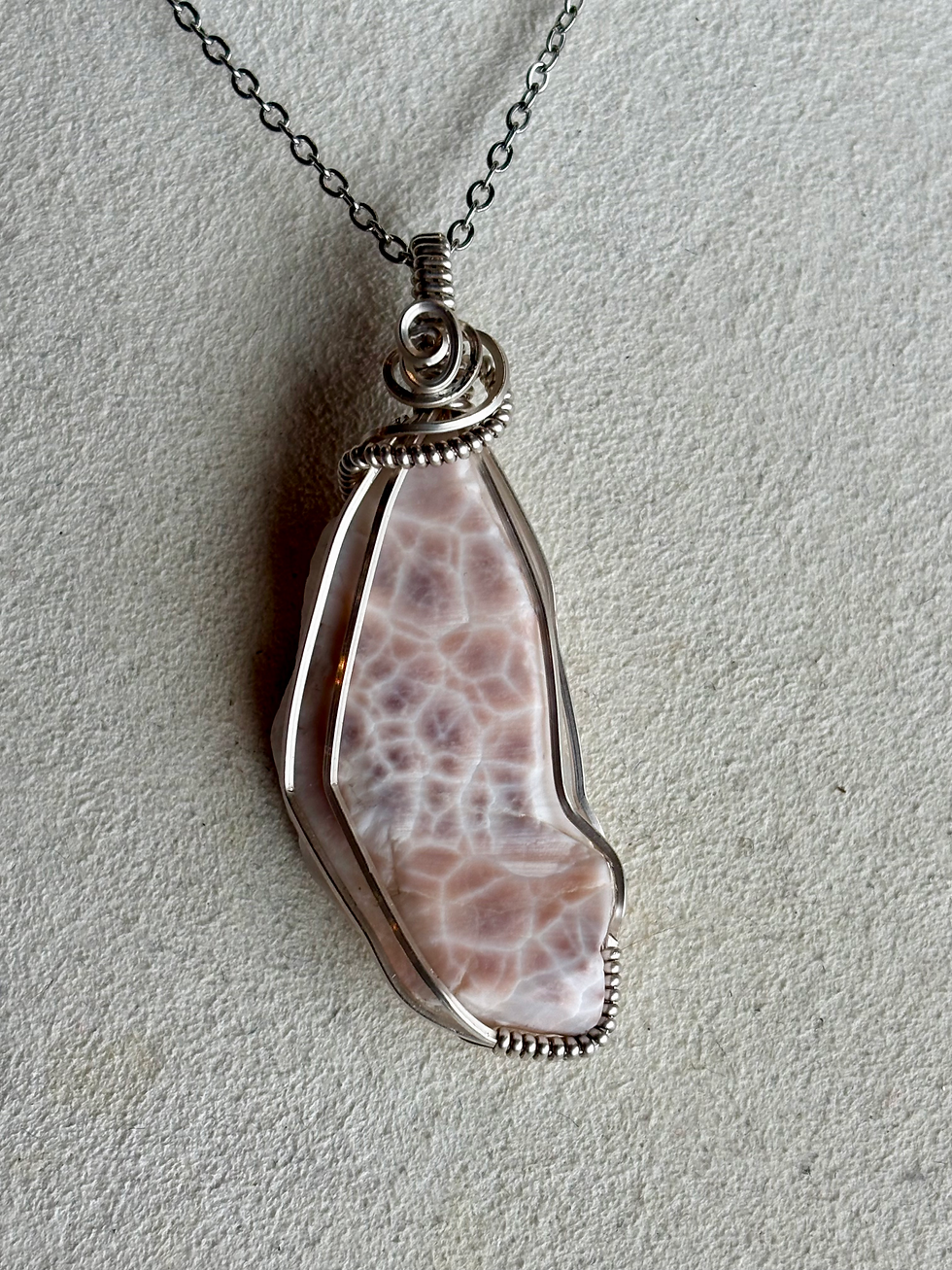 Pink spotted stone in silver necklace setting