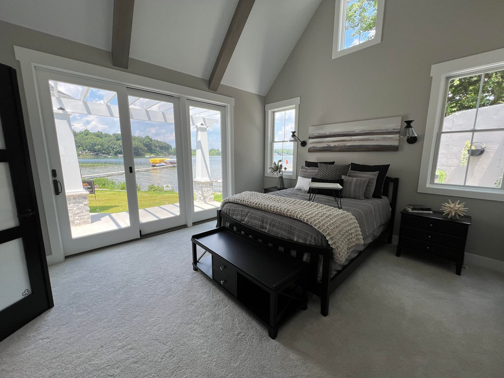 Owners suite with a large bed and a view of a lake
